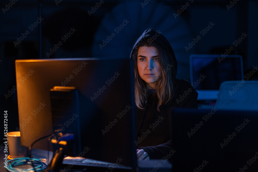 Poster cybercrime, hacking and technology concept - female hacker in dark room writing code or using comput