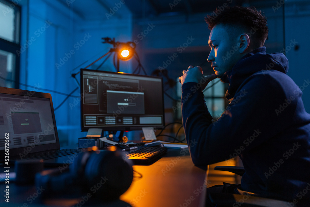 Poster cybercrime, hacking and technology concept - male hacker in dark room using computer virus program f