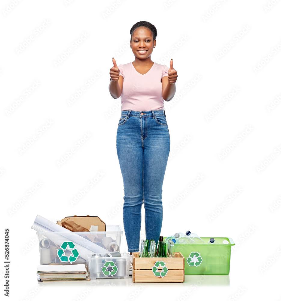 Wall mural recycling, waste sorting and sustainability concept - smiling young african american woman with plastic and glass bottles, papers and metal tin cans in boxes showing thumbs up over white background