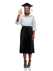 education, graduation and people concept - happy graduate student woman or bachelor in mortarboard showing ok gesture over white background