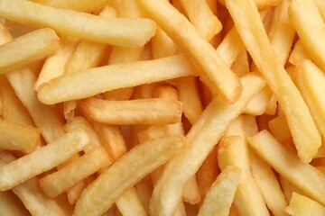 Many delicious French fry pieces as background