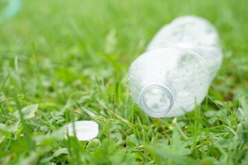 Plastic water bottles thrown on green grass concept campaign to separate plastic waste for recycling