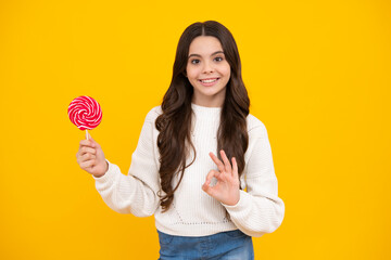 Teenage girl with lollipop, child eating sugar lollipops, kids sweets candy shop. Excited teenager girl. Happy face, positive and smiling emotions of teenager girl.