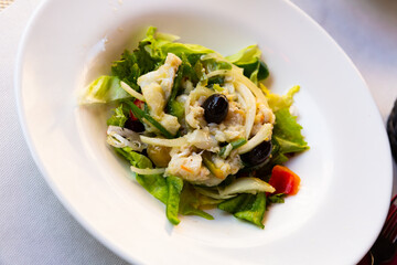 Tasty salad esqueixada of shredded salt cod, onions, greens and olives. Traditional Catalan dish..