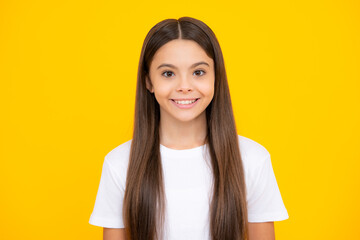 Happy teenager portrait. Portrait of cute positive little girl isolated on yellow background. Attractive caucasian child smiling and looking at camera. Smiling girl.