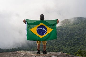 Young Man at Mountain Looking to Horizon in Nature with brazilian Flag.