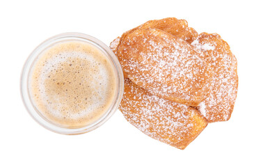 Delicious madeleine cakes with powdered sugar and glass of latte on white background, top view