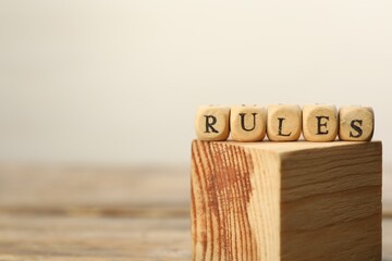 Word Rules made of cubes with letters on wooden block, space for text