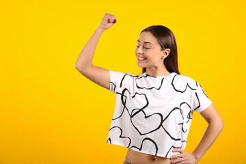 Strong woman as symbol of girl power on yellow background, space for text. 8 March concept