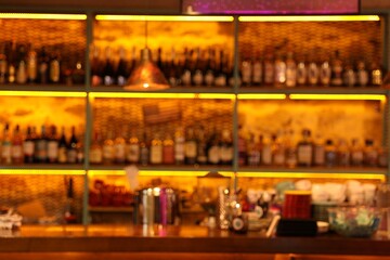 Blurred view of bottles on shelves in bar