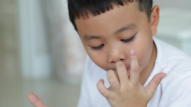 Asian allergy kid used his finger wipe  snot from his nose.