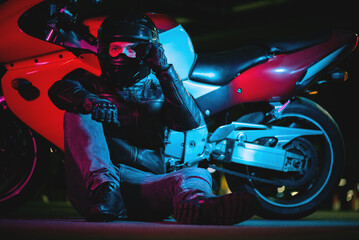 Motorbiker in the helmet is sitting on the road concept.