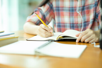 Close up young asian woman study in front of the noetbook at office.