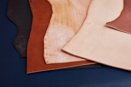 Close up of genuine leather pieces on table in craftsmans shop, copy space