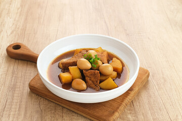 Semur, Indonesian traditional food, with tofu, quail eggs and potatoes, served in a bowl.

