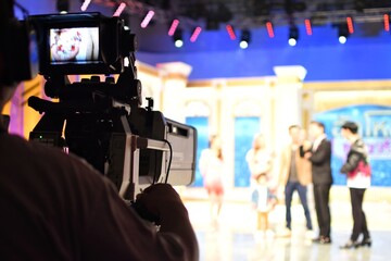 A cameraman's back view with a high quality television camera in television production.