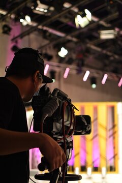 A cameraman's back view with a high quality television camera in television production.