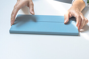 Girl's hands holding a tablet in a case. Preparing to work on a tablet