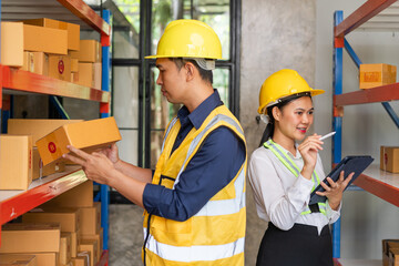 Asian man and woman Inventory Manager checking Stock of Parcels with Products Ready for Shipment.