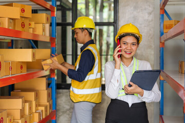 Asian man and woman Inventory Manager checking Stock of Parcels with Products Ready for Shipment.