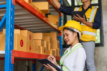 Asian man and woman Inventory Manager checking Stock of Parcels with Products Ready for Shipment.