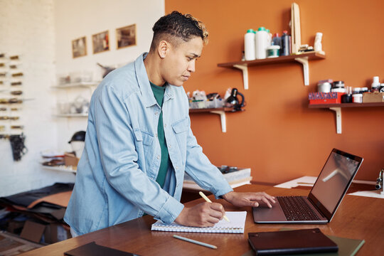 Side view portrait of modern woman using laptop while managing small business manufactory, copy space