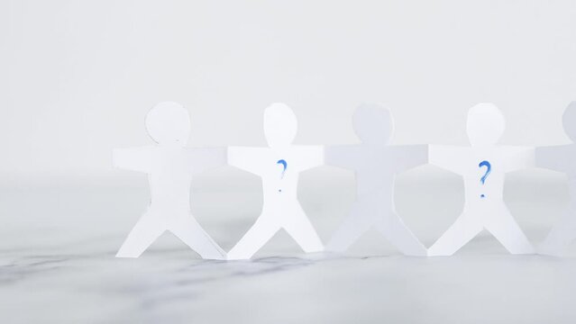 staff shortages and hiring personnel, paper people chain with question marks on some people symbol of positions to be filled