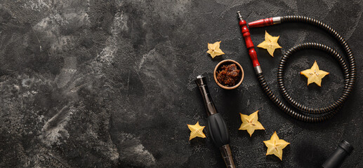 Parts of hookah and carambola on dark grunge background with space for text