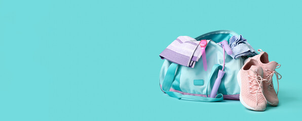 Sports bag and shoes on light blue background with space for text
