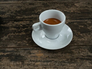 Espresso Coffee  in white cup on brown wooden table , Hot drink on ceramic plate