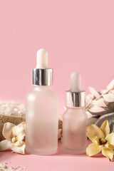 Fototapeta na wymiar Bottles of essential oil on pink background, closeup