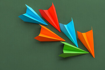 Colorful paper planes on green background