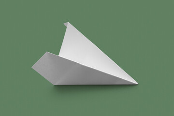 White paper plane on green background