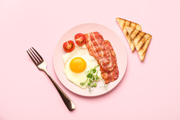 Plate with tasty fried egg, bacon and toasts on pink background