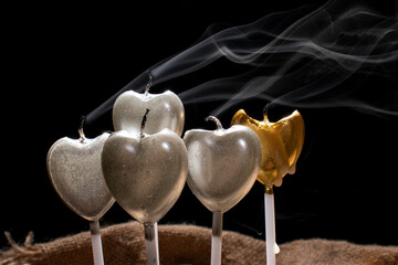 grupo de velas en forma de corazon recien apagadas y su rastro de humo