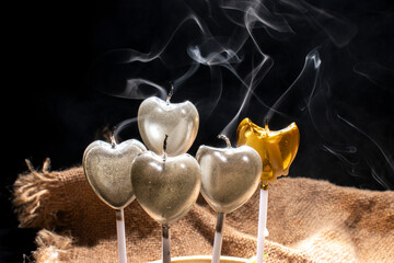 grupo de velas en forma de corazon recien apagadas y su rastro de humo