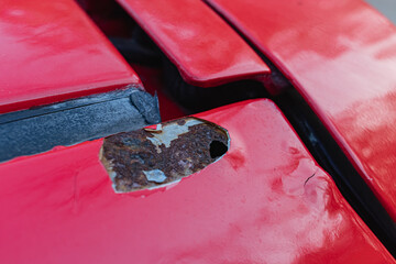 Holes caused by rust on the red car body
