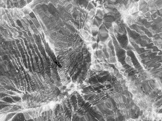 Sunlight creates a pattern on a wavy water surface