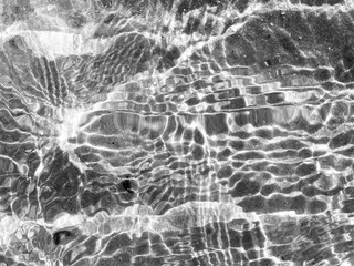 Sunlight creates a pattern on a wavy water surface