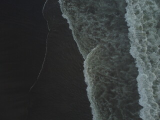 Cold waves on the black sand beach