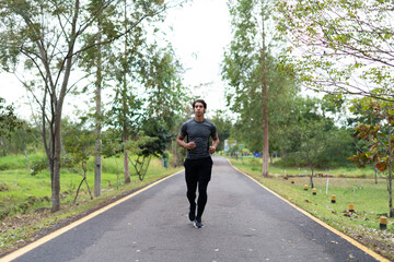 Fitness man exercising in the park and listening to music with headphones. Concept of people and sport