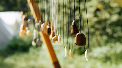 Craft handmade wooden jewelry decorations hanging outdoors. Sale of rustic ancient amulets....