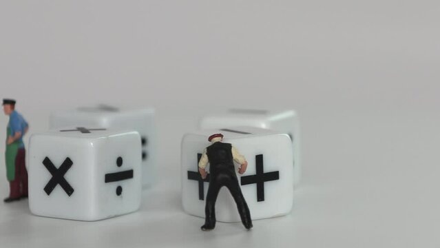 Four&nbsp;white&nbsp;dice&nbsp;with&nbsp;mathematical&nbsp;math&nbsp;symbols. Business concept with miniature people.
