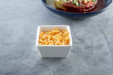 A view of a condiment cup of Mexican rice, as a side dish.
