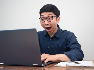 Asian businessman using laptop for working feels amazed