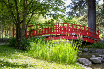 Traditional red wooden bridge on a japanese garden pond