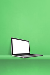 Laptop computer on green shelf. Vertical background