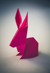 Pink paper rabbit origami isolated on blank background