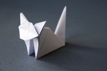 White paper cat origami isolated on a grey background
