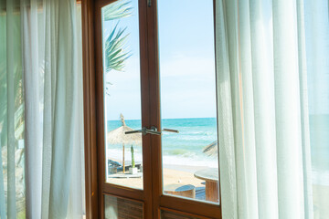 curtain and glass window with sea beach view outside